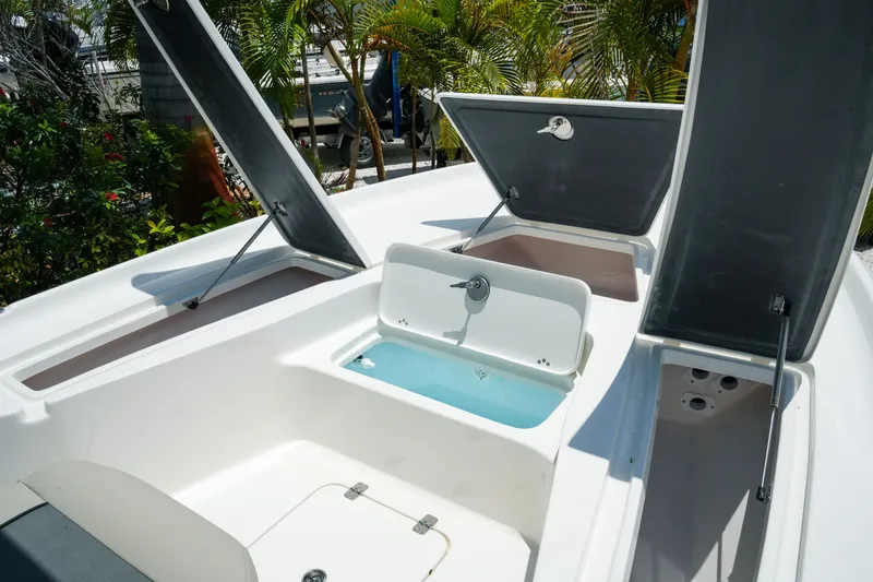 Slide: The Image of 2027 Key West 230 Bay Reef boat interior with open storage compartments and livewell. - 20