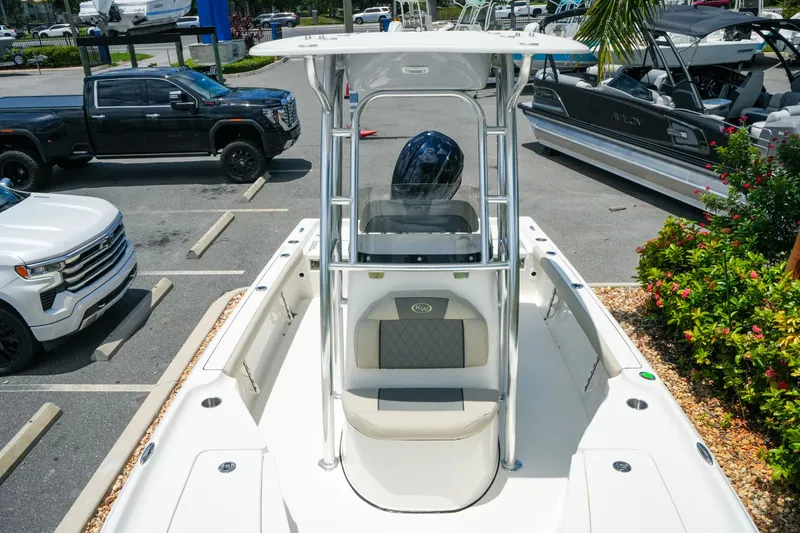 Slide: The Image of 2027 Key West 230 Bay Reef boat in parking lot, surrounded by vehicles and greenery. - 23