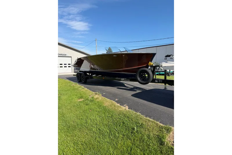 Slide: The Image of 2025 StanCraft 260 Day Boat on trailer outside showroom under clear blue sky. - 29