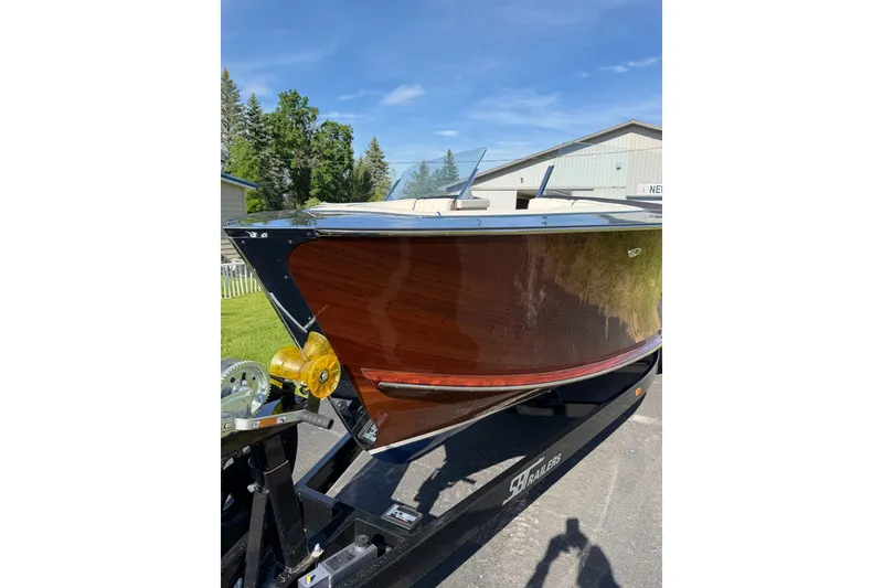 Slide: The Image of 2025 StanCraft 260 Day Boat with sleek wooden finish on a trailer. - 25