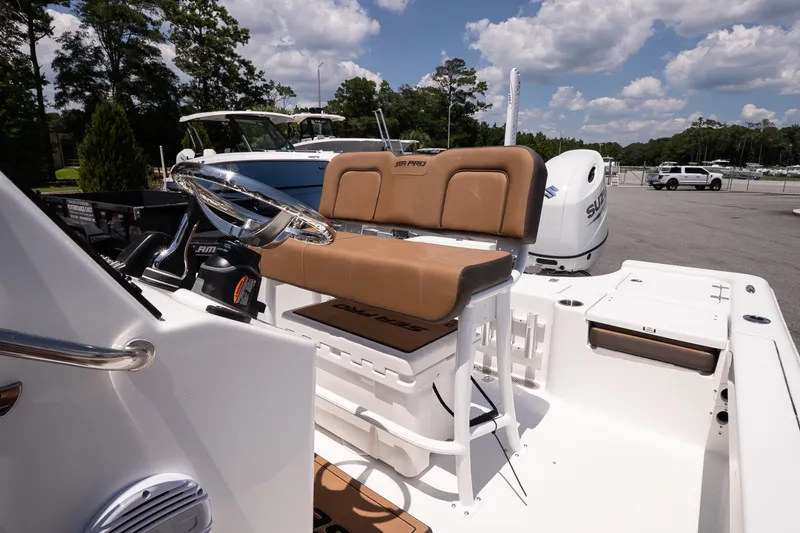 Slide: The Image of 2027 Sea Pro 210 Bay boat interior with tan seating and steering wheel. - 14