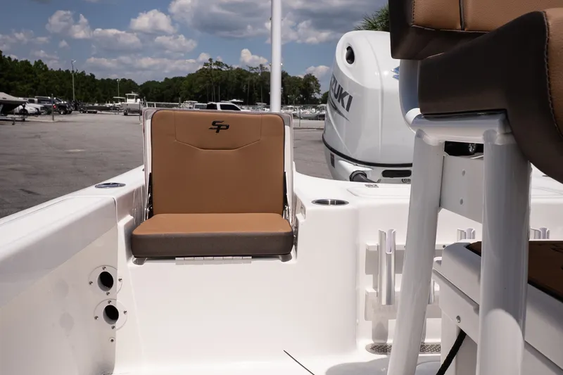 Slide: The Image of 2027 Sea Pro 210 Bay boat interior with tan seating and Suzuki outboard motor. - 16