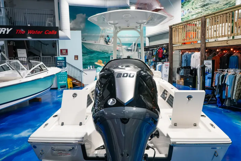 Slide: The Image of 2027 Pathfinder 2200 Hybrid boat displayed in a showroom with vibrant blue flooring. - 13