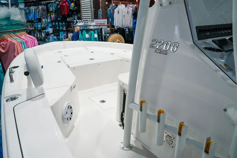 Slide: The Image of 2027 Pathfinder 2200 Hybrid boat displayed in a showroom with colorful clothing. - 17
