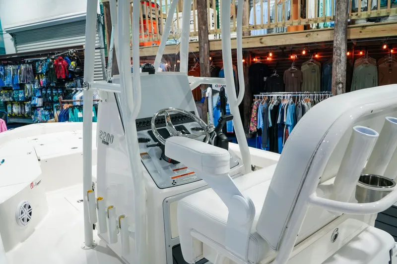Slide: The Image of Interior view of 2027 Pathfinder 2200 Hybrid boat in a showroom setting. - 16