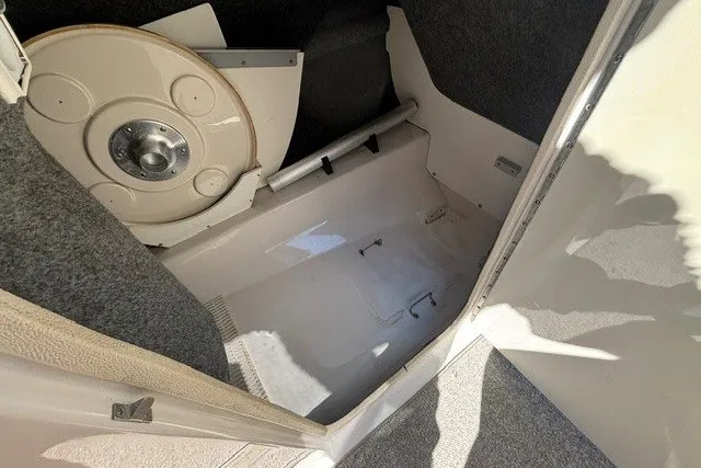 Slide: The Image of Storage compartment of a 2004 Sea Ray 200 Sundeck boat, featuring a circular hatch. - 17