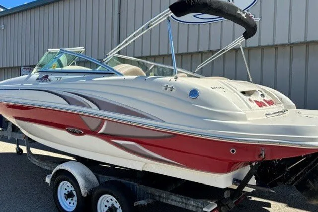 Slide: The Image of 2004 Sea Ray 200 Sundeck boat on trailer, featuring sleek red and white design. - 21