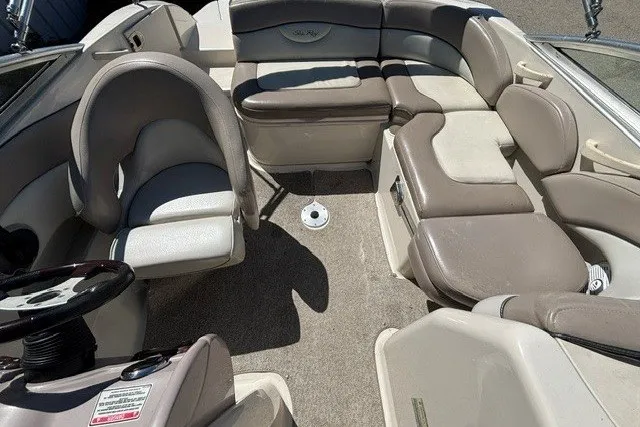 Slide: The Image of 2004 Sea Ray 200 Sundeck interior with beige seating and steering wheel. - 9