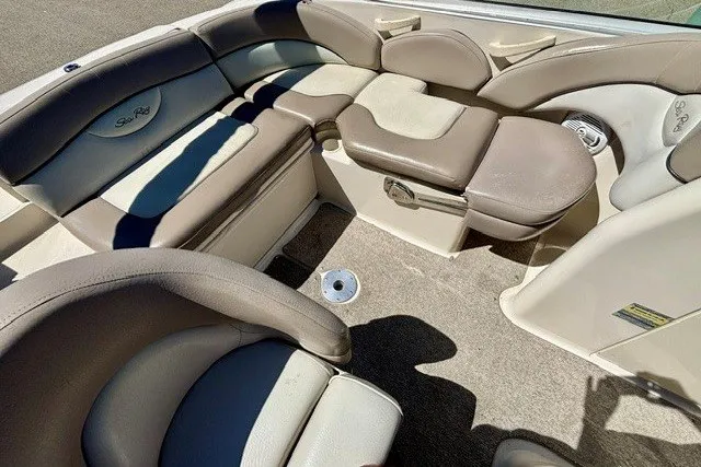 Slide: The Image of 2004 Sea Ray 200 Sundeck interior with beige seating and carpeted flooring. - 11