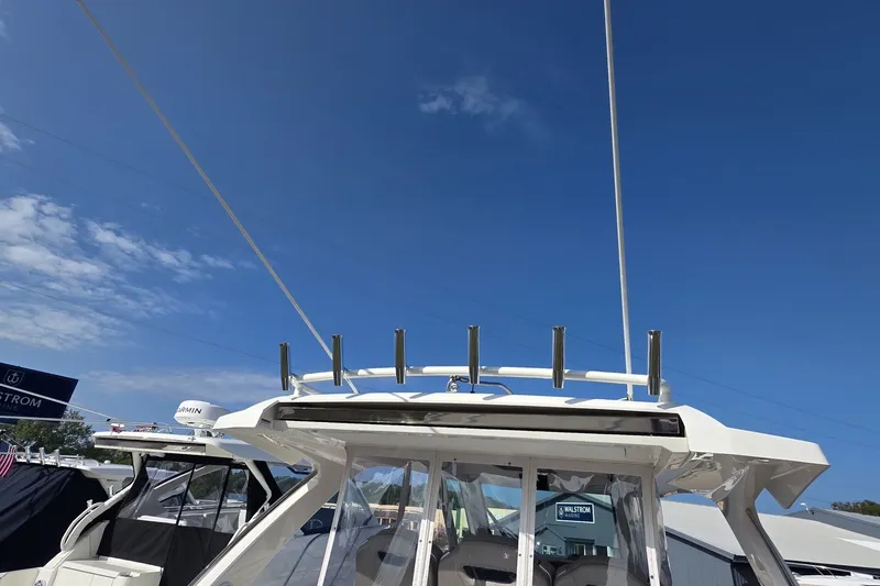 Slide: The Image of 2024 Tiara Sport 34LS boat with rod holders against a clear blue sky. - 34