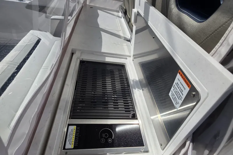 Slide: The Image of Built-in grill on 2024 Tiara Sport 34LS boat, featuring safety warning label. - 32