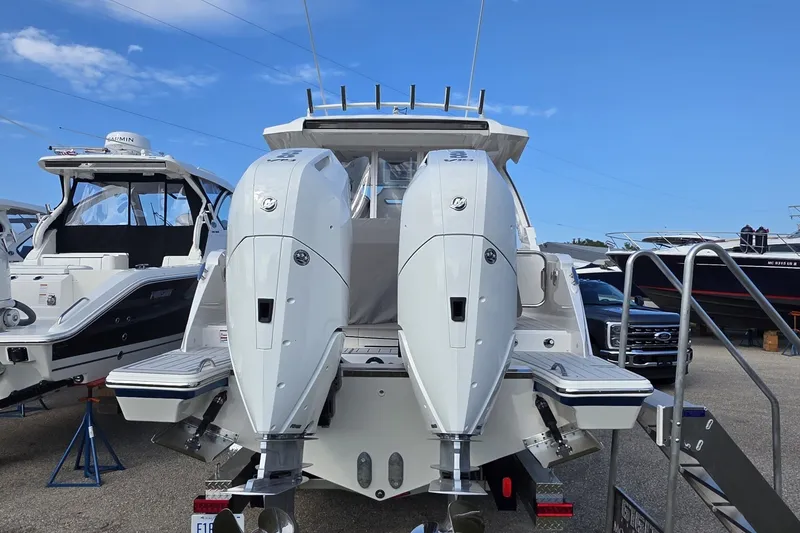 Slide: The Image of 2024 Tiara Sport 34LS boat with dual outboard engines, docked at a marina. - 36