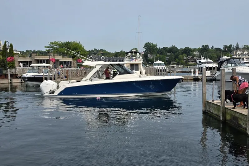 The Image of 2024 Tiara Sport 34LS boat docked in a scenic marina setting. - 0