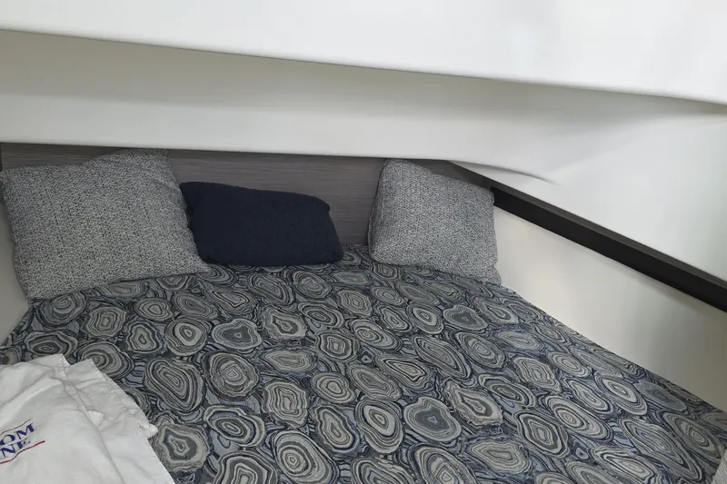 Slide: The Image of Cozy cabin interior of 2024 Tiara Sport 34LS with patterned bedding and pillows. - 18