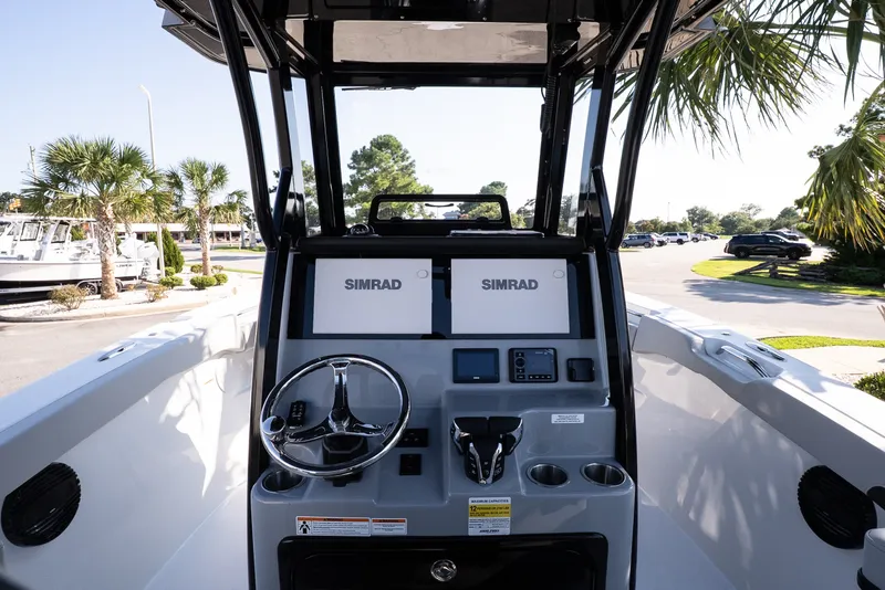 Slide: The Image of 2027 Sea Pro 262 Offshore boat dashboard with dual Simrad displays and steering wheel. - 8