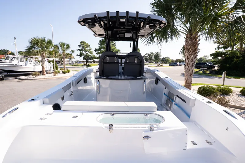 Slide: The Image of 2027 Sea Pro 262 Offshore boat interior with seating and palm trees in the background. - 7