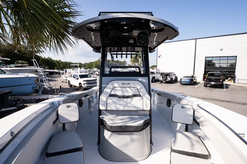 Slide: The Image of 2027 Sea Pro 262 Offshore boat interior at marina, showcasing seating and helm station. - 13