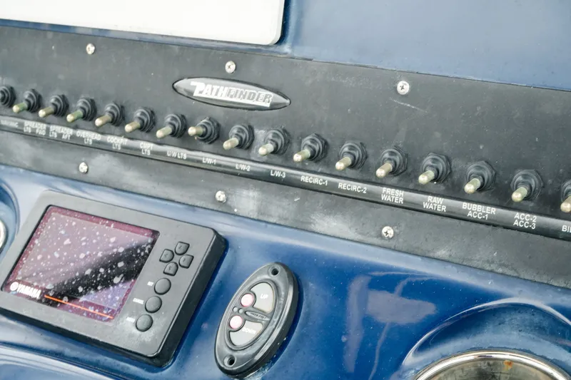 Slide: The Image of Control panel of a 2021 Pathfinder 2300 HPS boat with switches and display. - 13