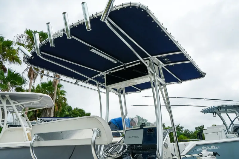 Slide: The Image of 2021 Pathfinder 2300 HPS boat with T-top and Garmin electronics, docked near palm trees. - 9