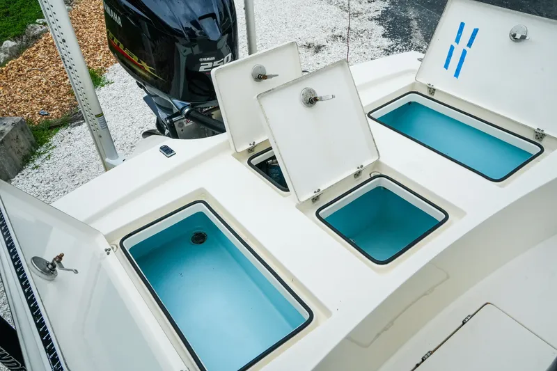 Slide: The Image of 2021 Pathfinder 2300 HPS boat with open storage compartments and Yamaha outboard motor. - 24