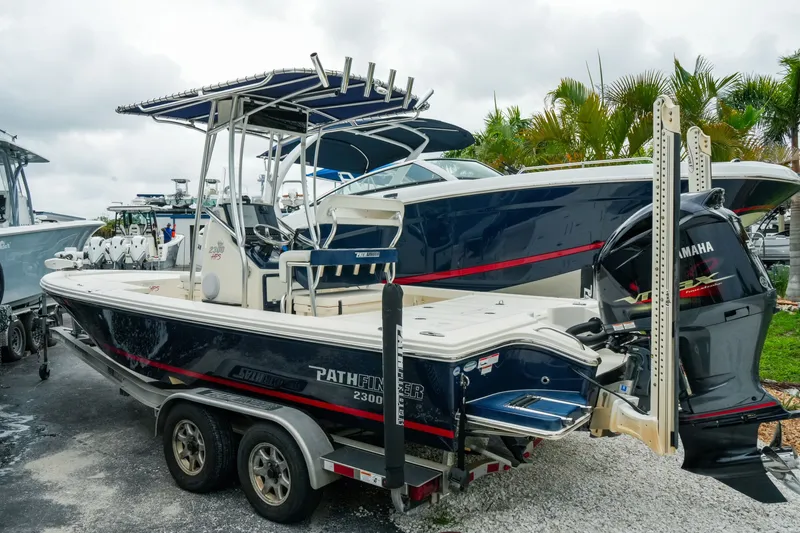 Slide: The Image of 2021 Pathfinder 2300 HPS boat with Yamaha engine on trailer, parked outdoors. - 2