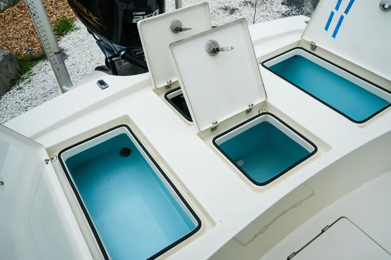 Slide: The Image of 2021 Pathfinder 2300 HPS boat with open storage compartments and Yamaha engine. - 25