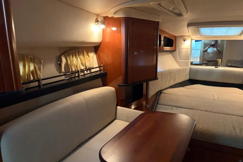 Slide: The Image of Interior of 2006 Sea Ray 290 Sundancer yacht with cozy seating and wooden cabinetry. - 13