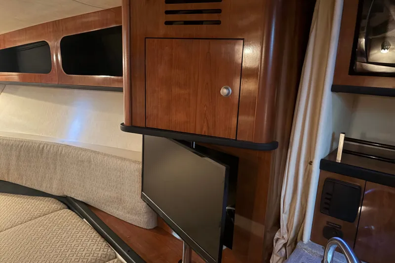 Slide: The Image of Interior of 2006 Sea Ray 290 Sundancer with wood cabinetry and mounted TV. - 16
