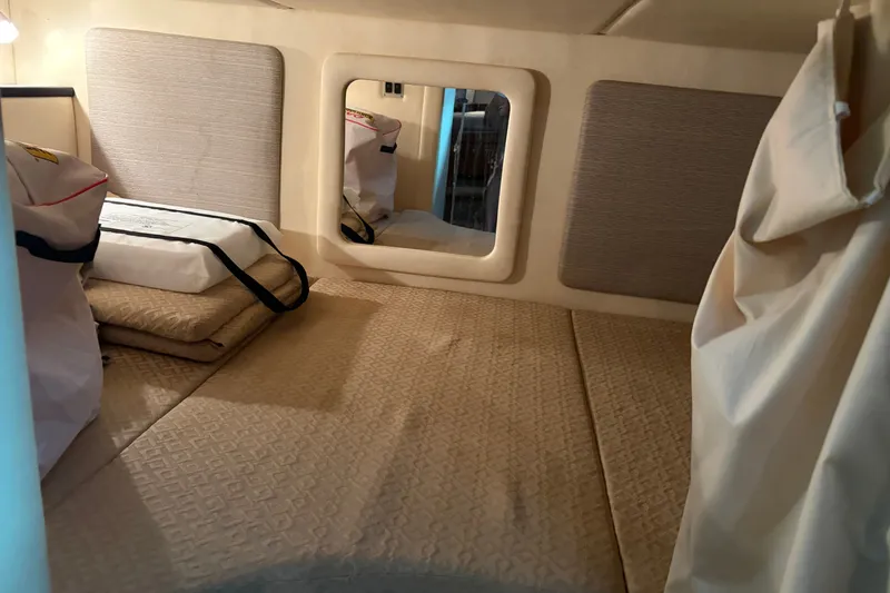 Slide: The Image of Interior cabin of 2006 Sea Ray 290 Sundancer with beige bedding and storage bags. - 24