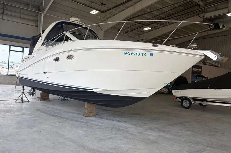 Slide: The Image of 2006 Sea Ray 290 Sundancer boat in a showroom, elevated on blocks. - 2