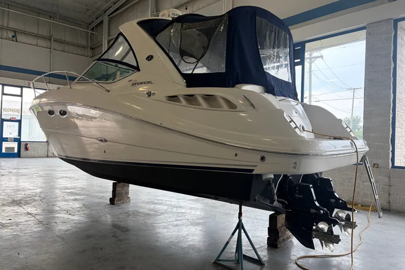 Slide: The Image of 2006 Sea Ray 290 Sundancer boat in a showroom, elevated for maintenance. - 1