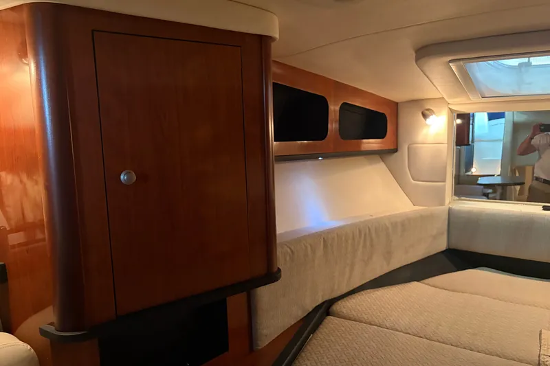Slide: The Image of Interior cabin of 2006 Sea Ray 290 Sundancer with wood paneling and cozy seating area. - 17