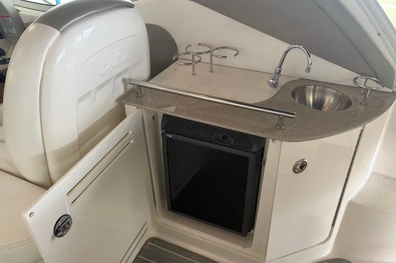 Slide: The Image of 2006 Sea Ray 290 Sundancer boat interior with sink, mini fridge, and cup holders. - 7