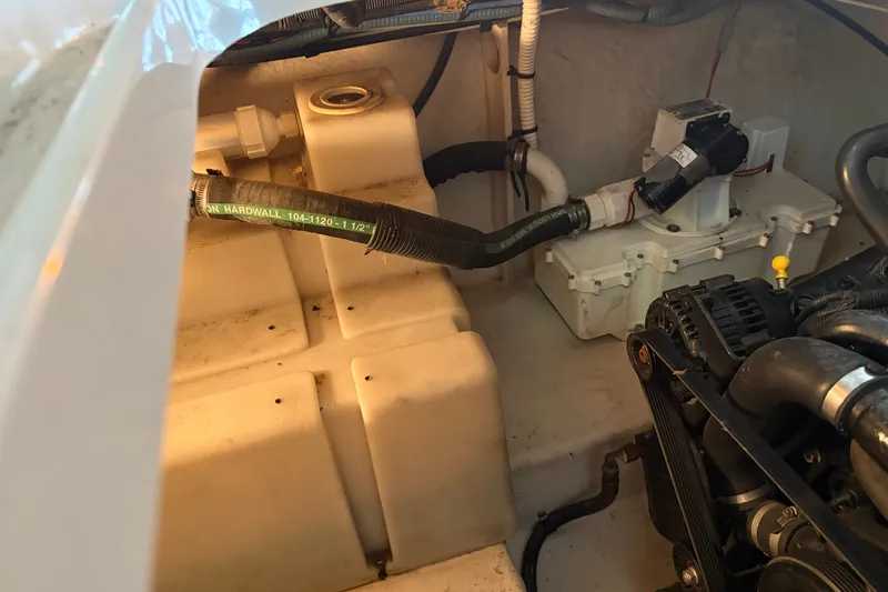 Slide: The Image of Engine compartment of a 2006 Sea Ray 290 Sundancer boat, showing hoses and components. - 30