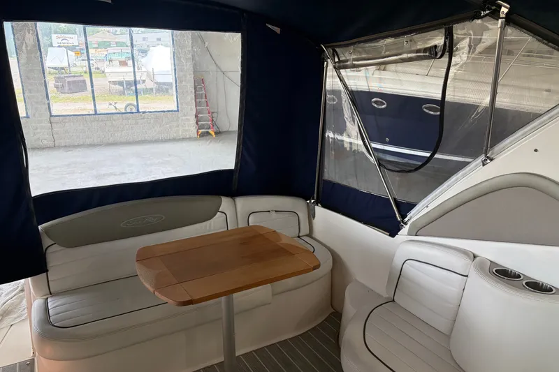 Slide: The Image of Interior of 2006 Sea Ray 290 Sundancer boat with seating and wooden table. - 5