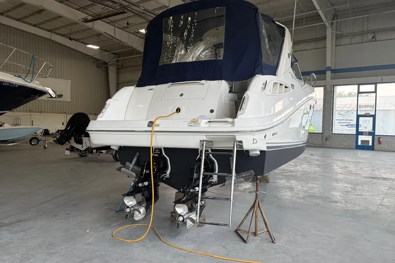 Slide: The Image of 2006 Sea Ray 290 Sundancer in a showroom, showcasing dual propellers and a covered cockpit. - 4