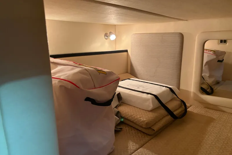 Slide: The Image of Interior cabin of 2006 Sea Ray 290 Sundancer with storage bags and bedding. - 23