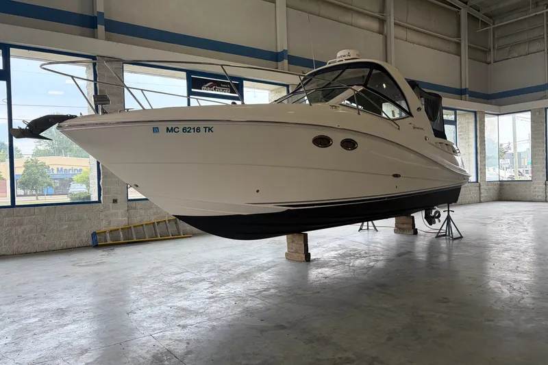 The Image of 2006 Sea Ray 290 Sundancer boat in indoor storage, elevated on blocks. - 0