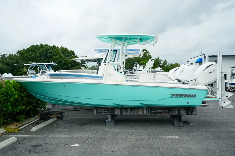 The Image of 2027 Pathfinder 2500 Tournament boat in mint green, parked outdoors on a cloudy day. - 0