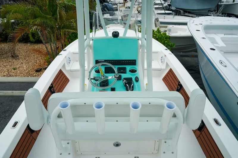 Slide: The Image of 2027 Pathfinder 2500 Tournament boat with sleek console and rod holders, docked near other vessels. - 14