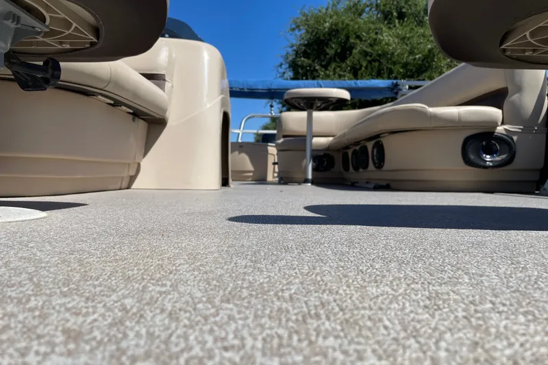 Slide: The Image of 2017 Sun Tracker Fishin' Barge 20 DLX interior with beige seating and textured flooring. - 31