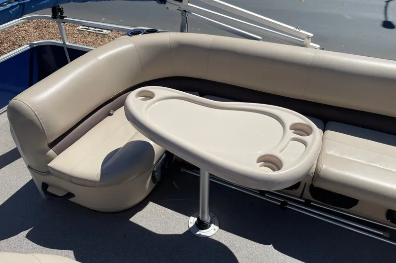 Slide: The Image of 2017 Sun Tracker Fishin' Barge 20 DLX interior with beige seating and table. - 30