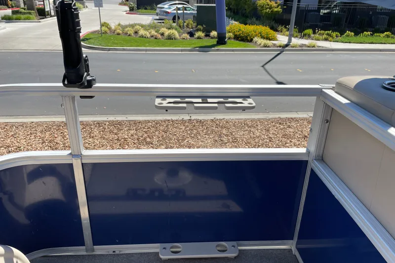 Slide: The Image of 2017 Sun Tracker Fishin' Barge 20 DLX interior view with rod holder, parked on street. - 14