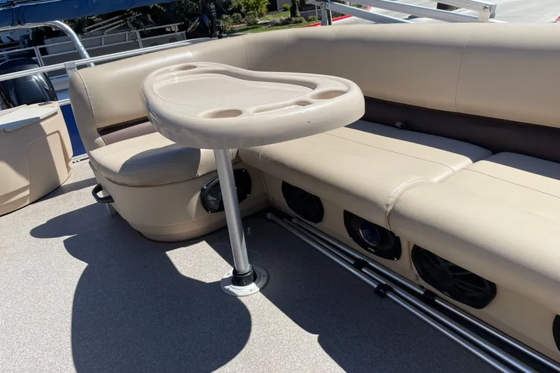 Slide: The Image of 2017 Sun Tracker Fishin' Barge 20 DLX interior with beige seating and table. - 29