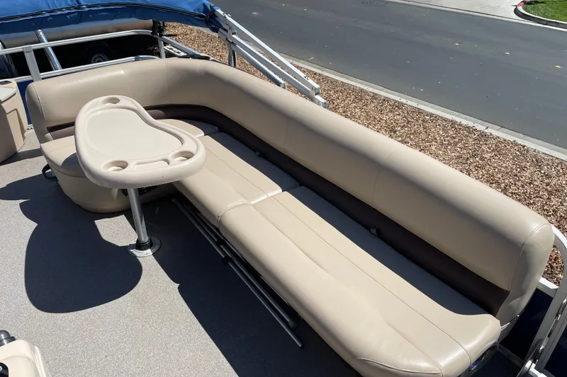 Slide: The Image of 2017 Sun Tracker Fishin' Barge 20 DLX with beige seating and cupholder table. - 28