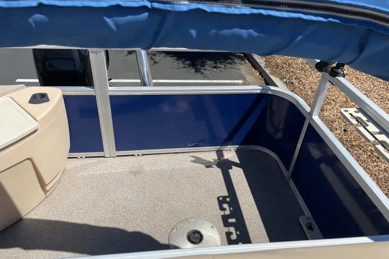 Slide: The Image of 2017 Sun Tracker Fishin' Barge 20 DLX interior with blue paneling and seating area. - 15