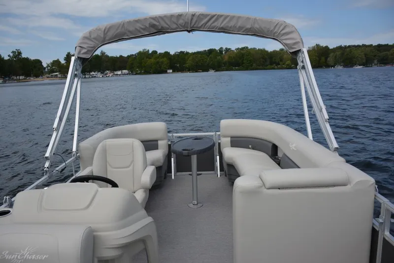 Slide: The Image of Manufacturer Provided Image: 2021 SunChaser Vista 20 LR pontoon boat on a lake with canopy and seating. - 9