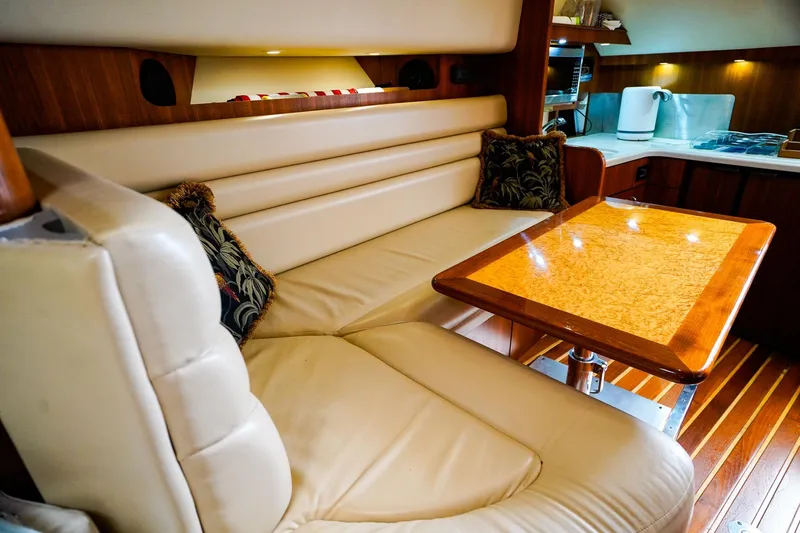 Slide: The Image of Luxurious interior of 2005 Tiara Yachts 3800 Open with leather seating and wooden table. - 28