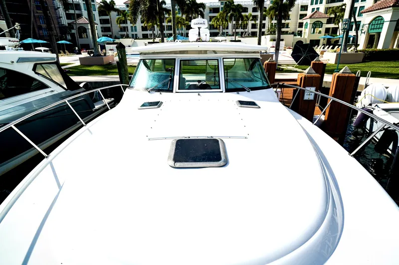 Slide: The Image of 2005 Tiara Yachts 3800 Open docked at a marina with palm trees in the background. - 38