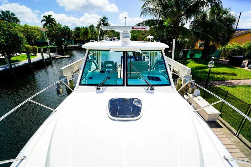 Slide: The Image of 2018 Boston Whaler 315 Conquest docked by a lush, tropical canal. - 29